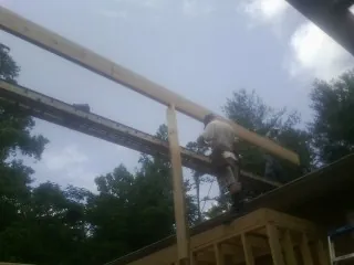 Carpenter setting a ridge beam over a new addition frame — Ice Dam Removal by Roofing Brothers in Rimforest