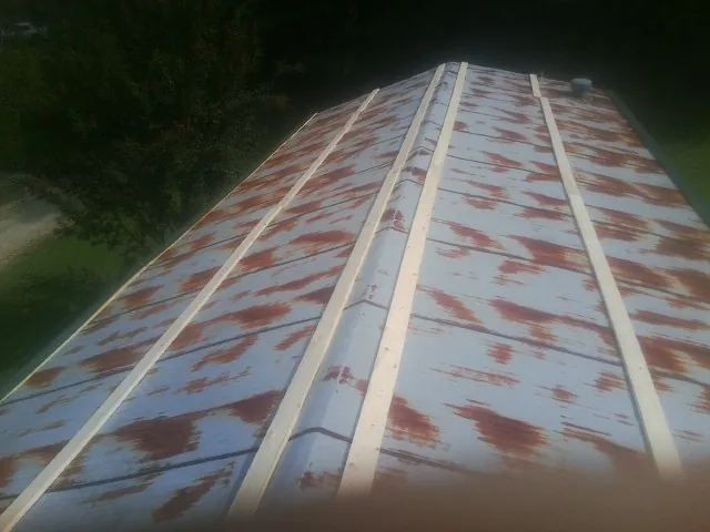 Rusted metal roof panels with new wood purlins before replacement — Storm Damage Roof Repair in Rimforest by Roofing Brothers