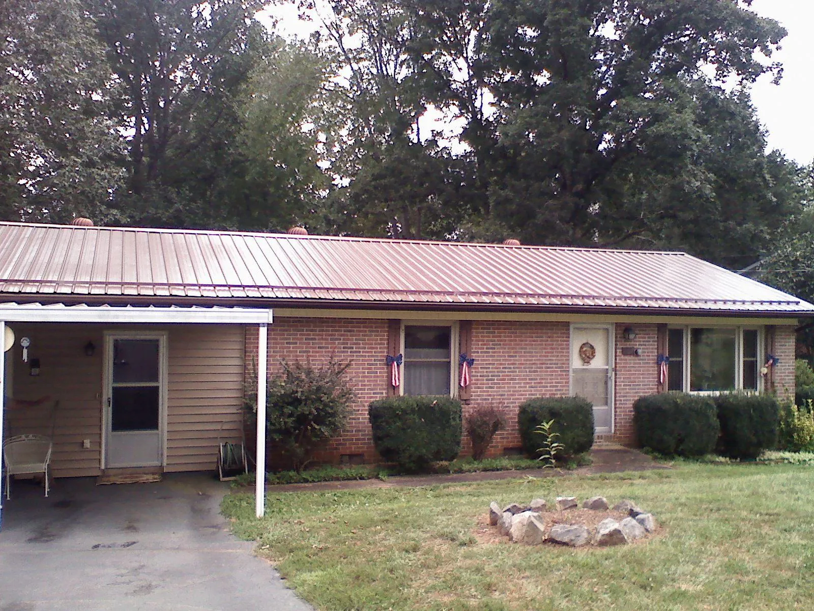 Bronze metal roof and carport on a brick ranch home — Roof Repair work by our crew in Rimforest